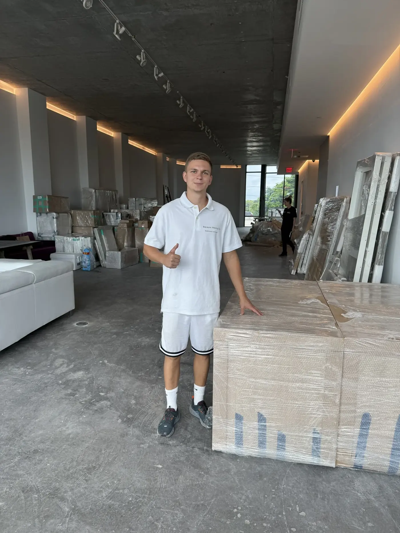 Biscayne Moving Co. crew member beside wrapped furniture during a South Florida move
