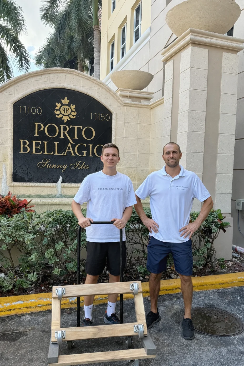 Two Biscayne Moving Co. movers with a dolly outside Porto Bellagio in Sunny Isles Beach