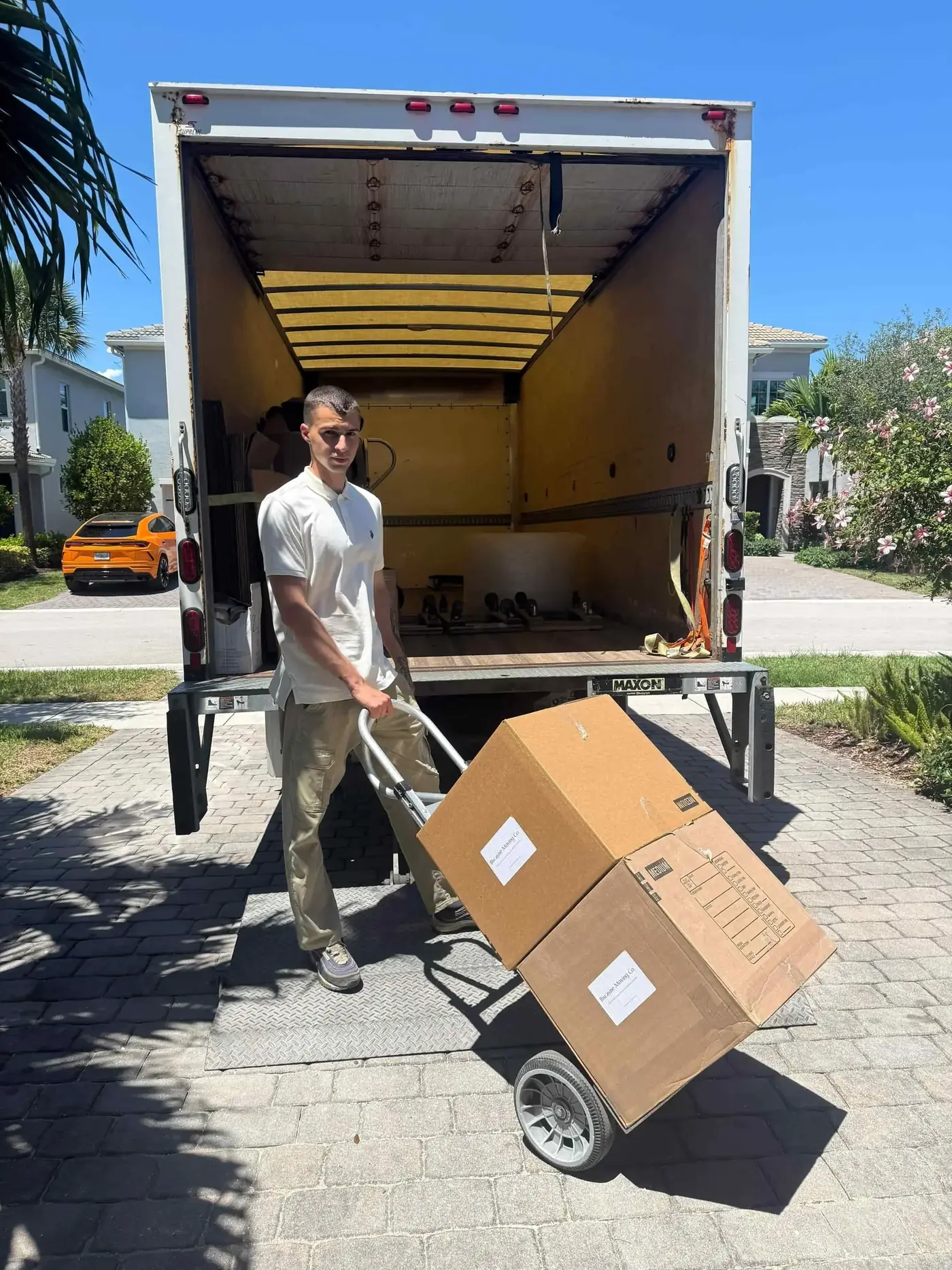 Mover rolling boxes from a Biscayne Moving Co. truck in Fort Lauderdale