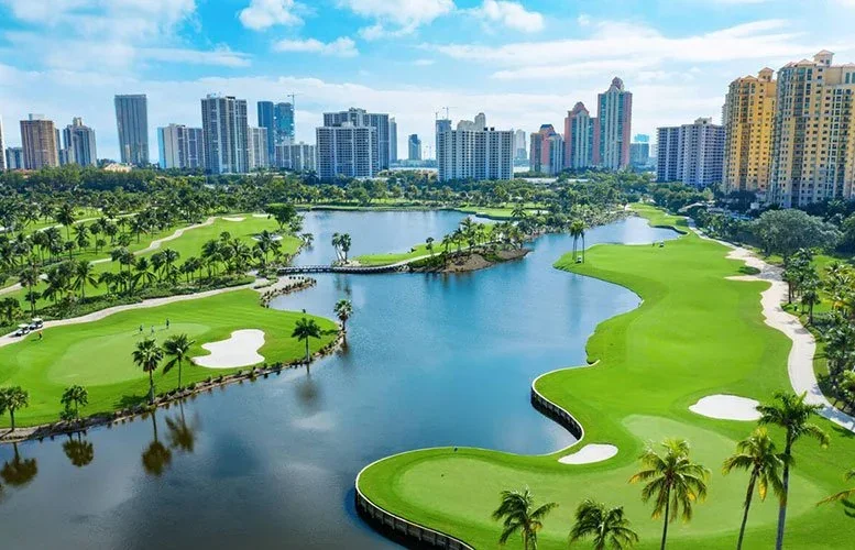 Aerial view of a golf course, lake, and high-rise condos in Aventura