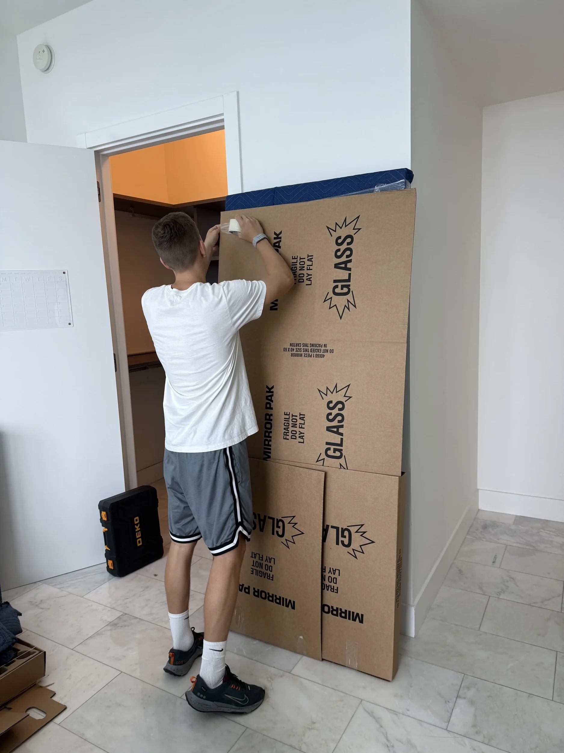 Mover protecting a doorway while preparing a Miami home for moving