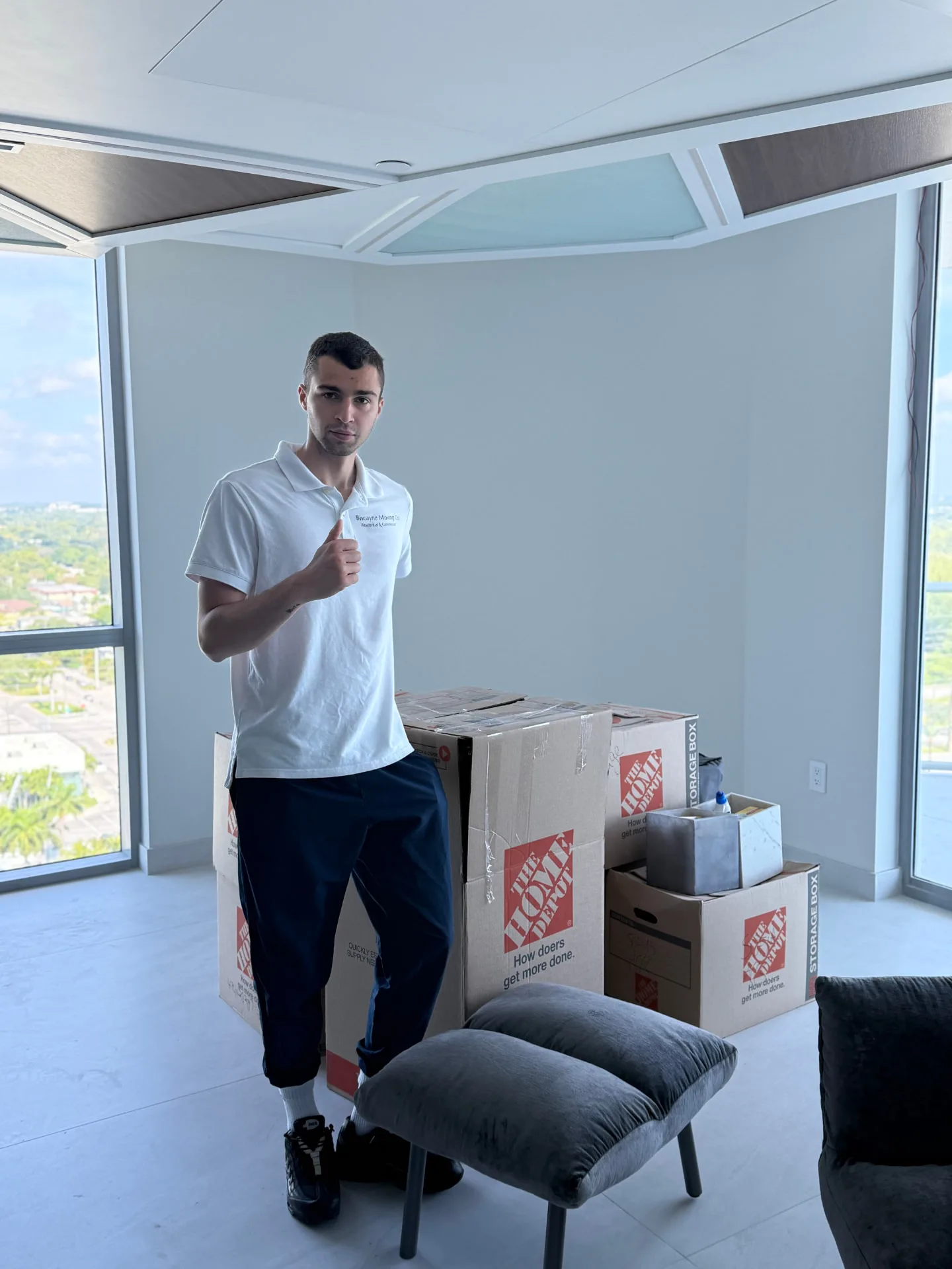Biscayne Moving Co. crew member beside stacked boxes at a Boca Raton high-rise move