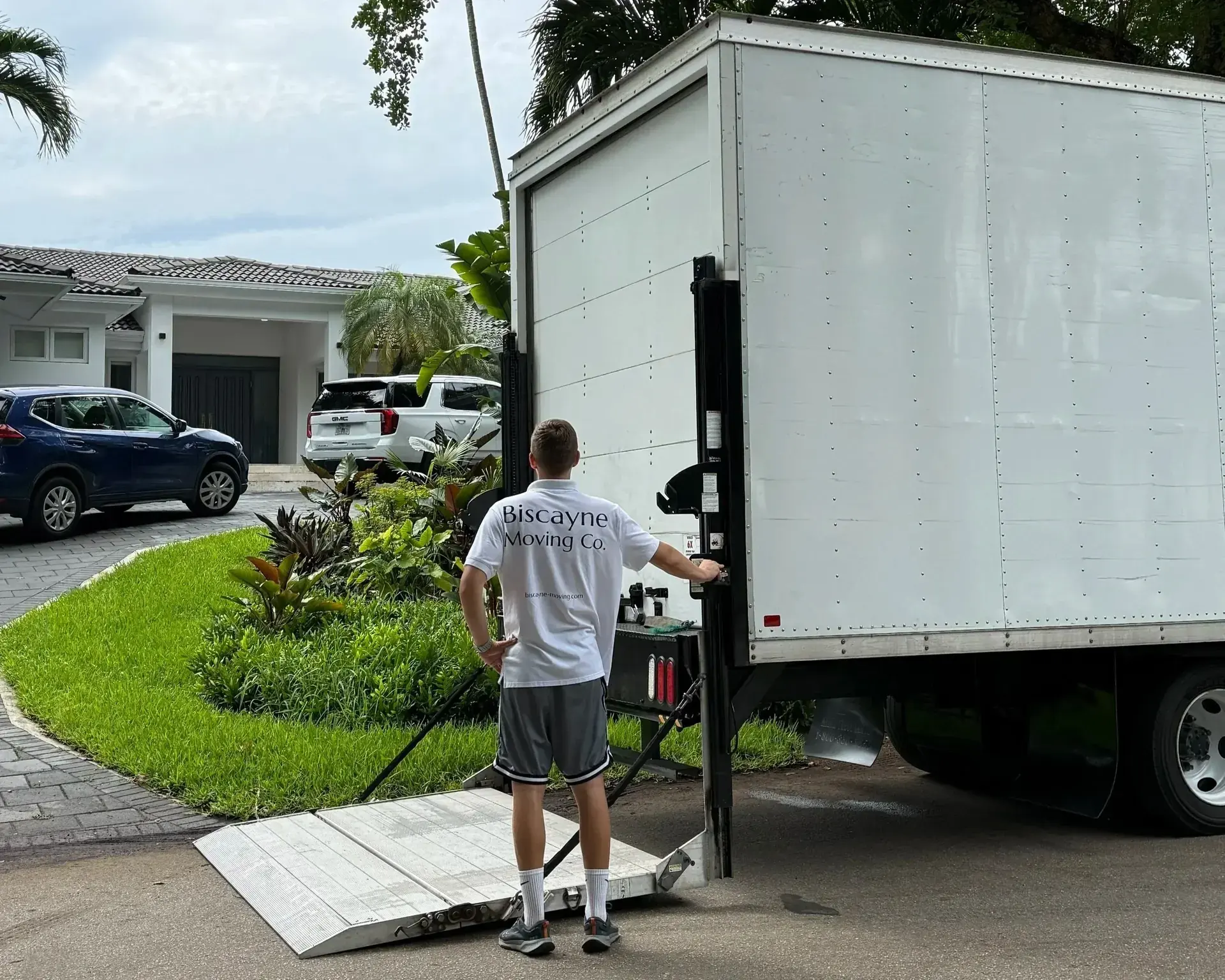 Mover lowering a truck ramp outside a South Florida home in summer