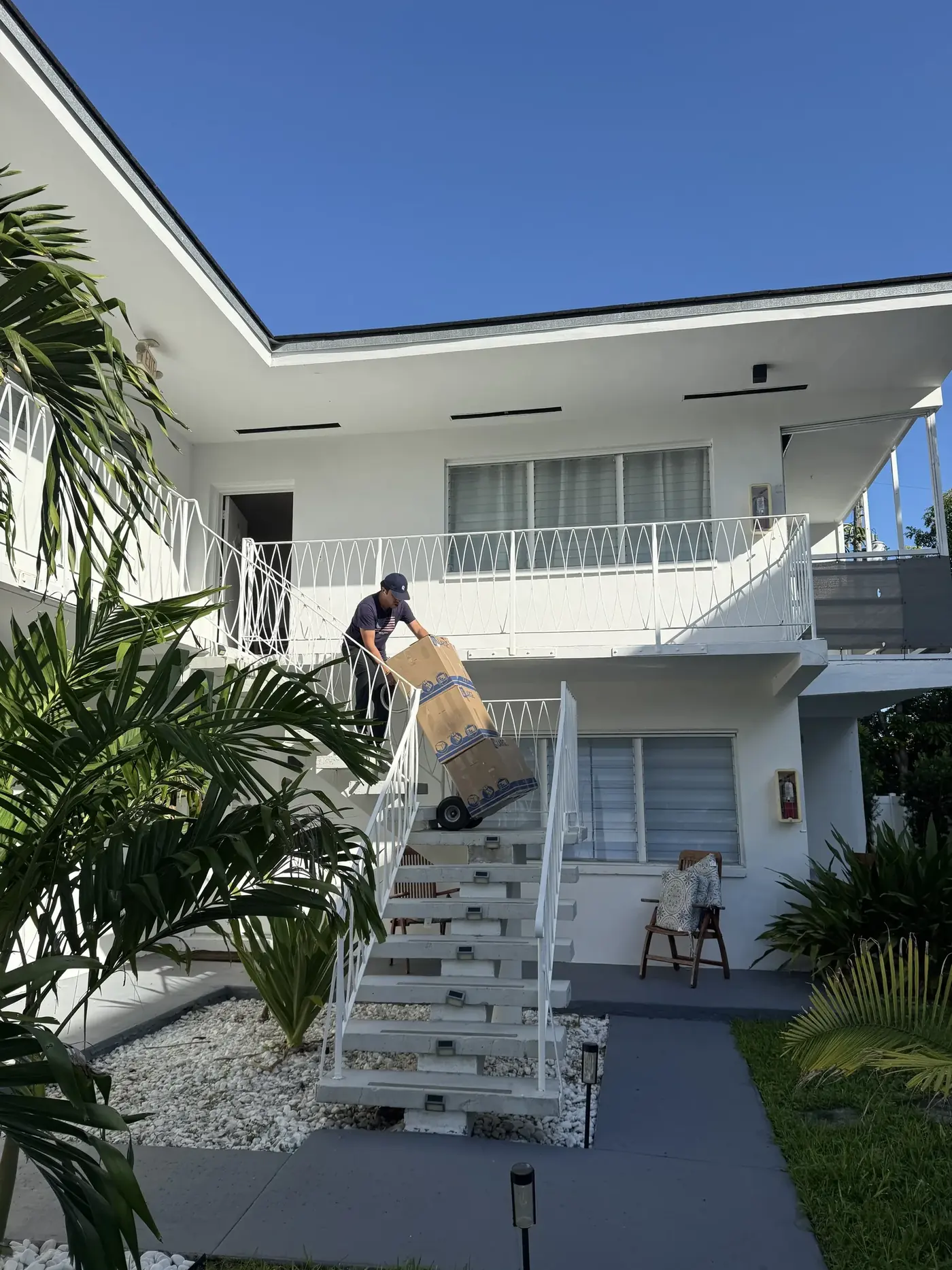 Biscayne Moving Co. mover carrying boxes down stairs at an Aventura home