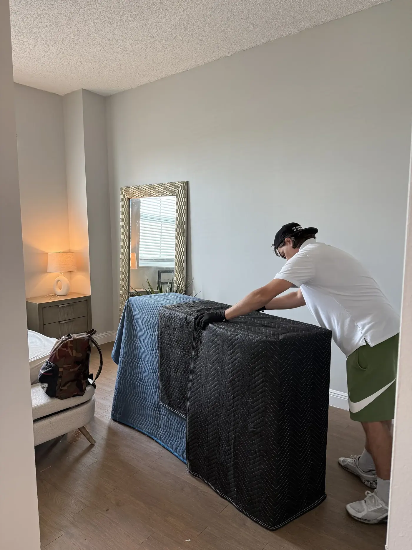 Mover wrapping a sofa inside an Aventura home