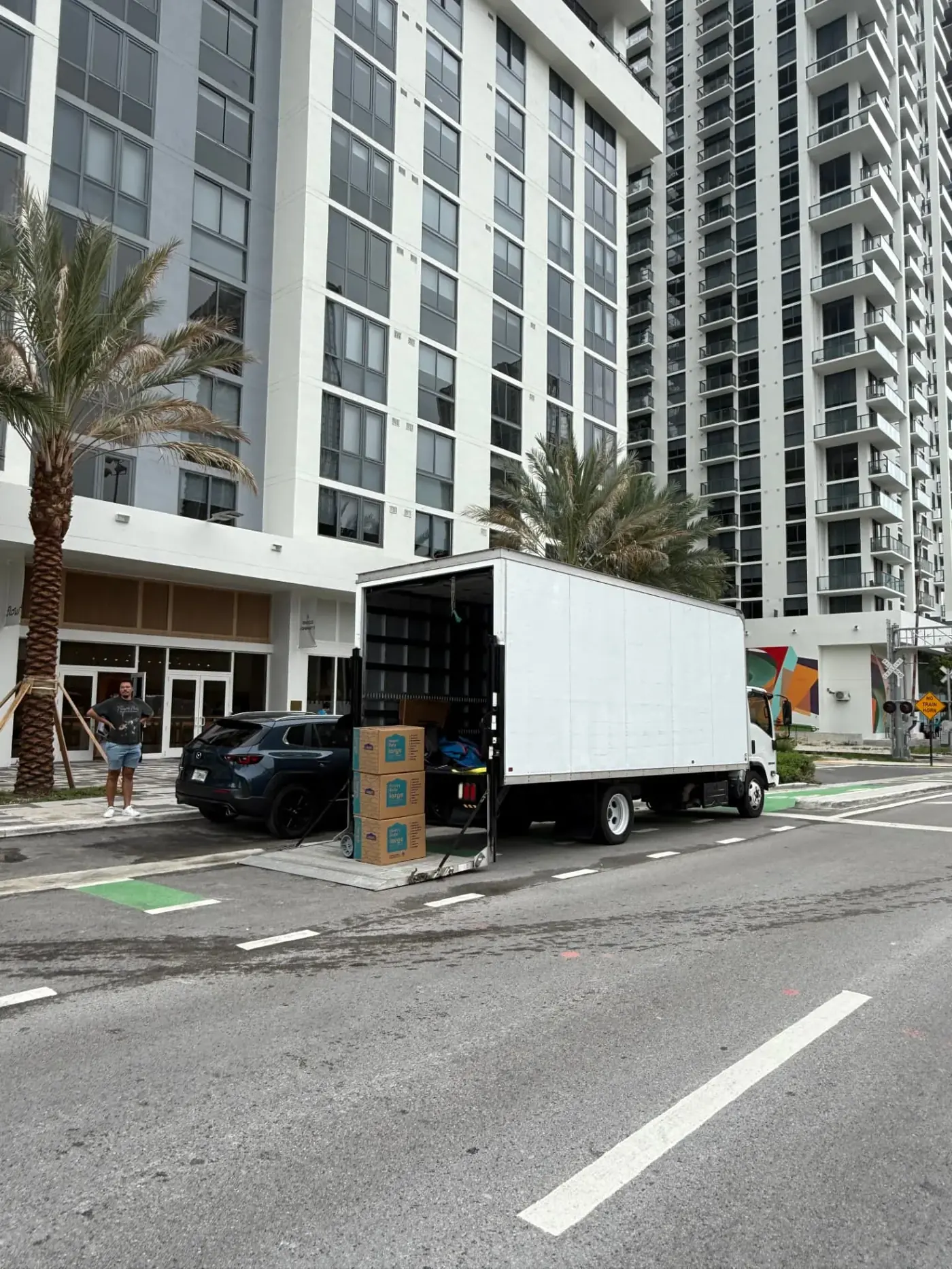 Biscayne Moving Co. truck loading boxes outside a Miami high-rise