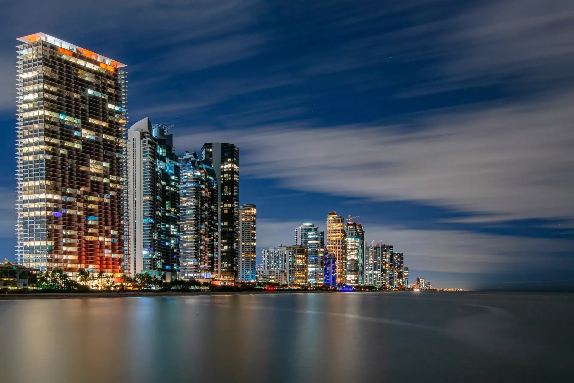 Sunny Isles Beach condo towers lit up at night along the waterfront